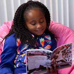 young girl using a Reading A-Z book at home